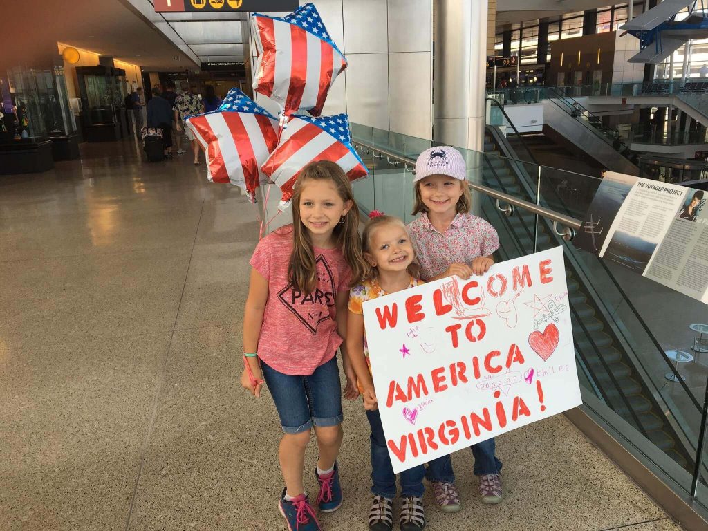 niños de Estados Unidos con cartel de bienvenida