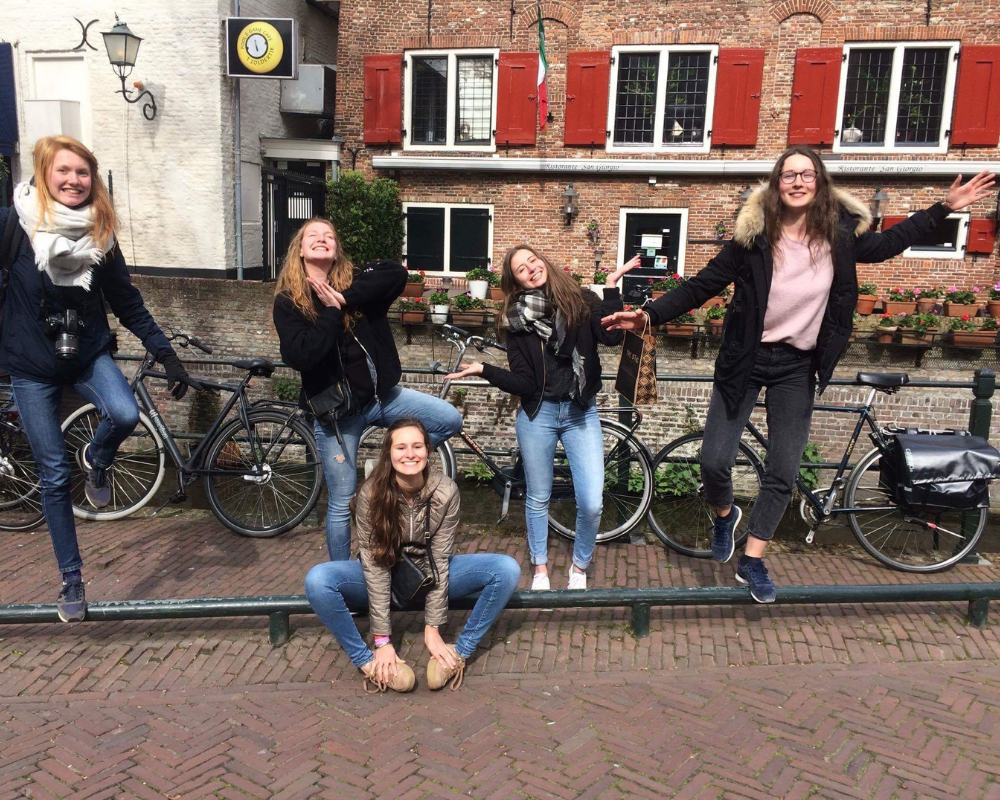 Amigos posando en bicicleta en una ciudad holandesa