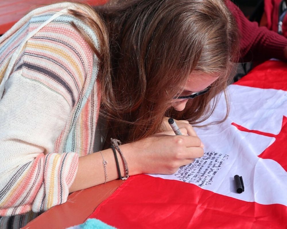 ragazza scrive dedica su bandiera canada