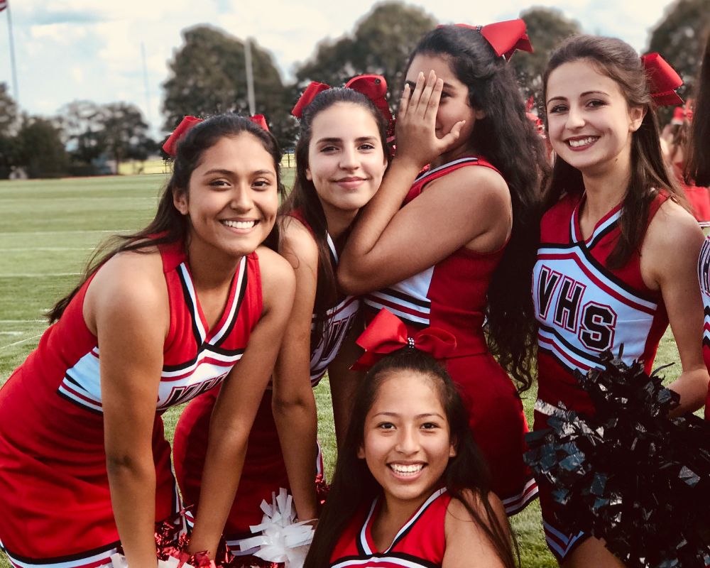 Ragazze in uniforme da cheerleader rossa in posa durante una partita