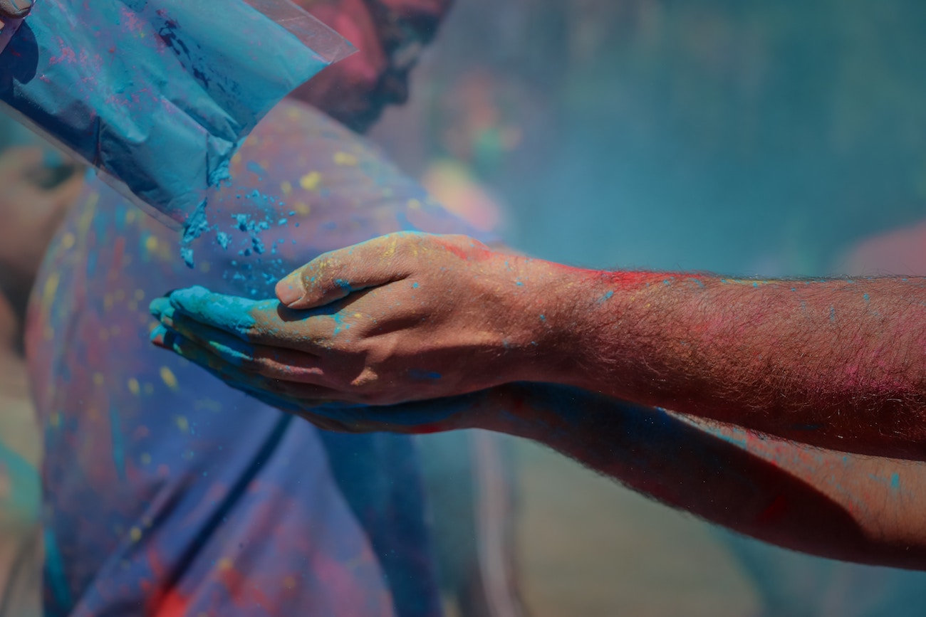 Holi Festival India - mani che stanno ricevendo polvere blu da un sacchetto