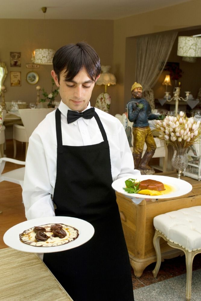 Cameriere serve ai tavoli per la prima volta