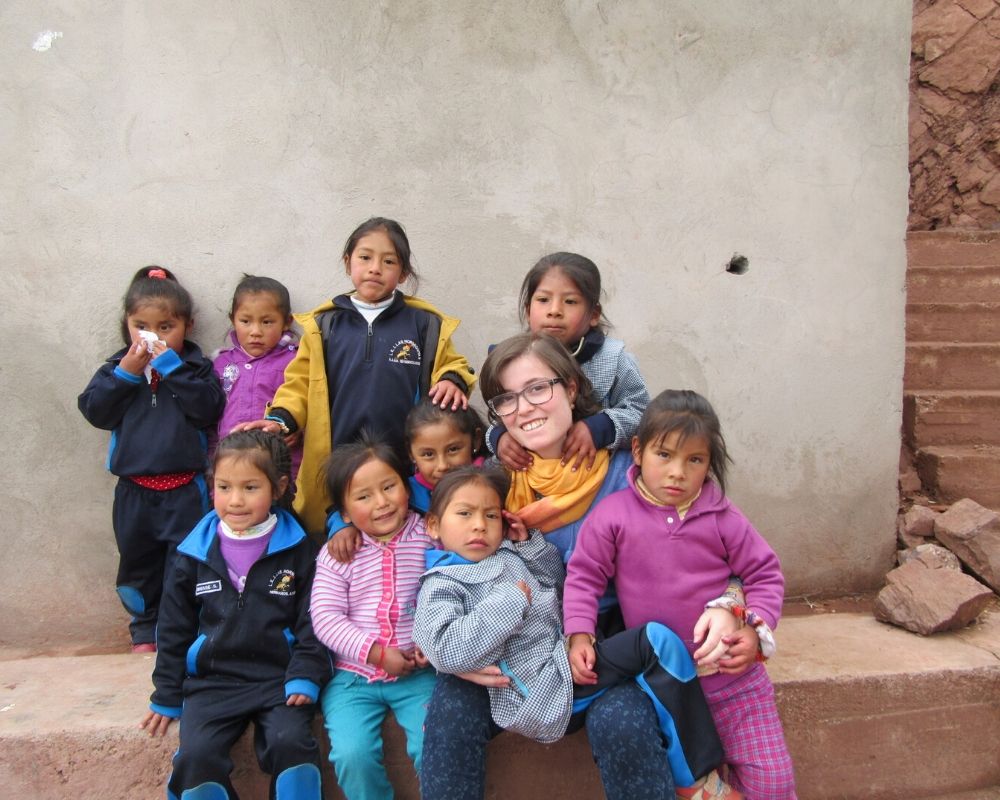 Ragazza con gruppo di bambine in Perù durante un viaggio solidale per scoprire se stessa e che strada intraprendere