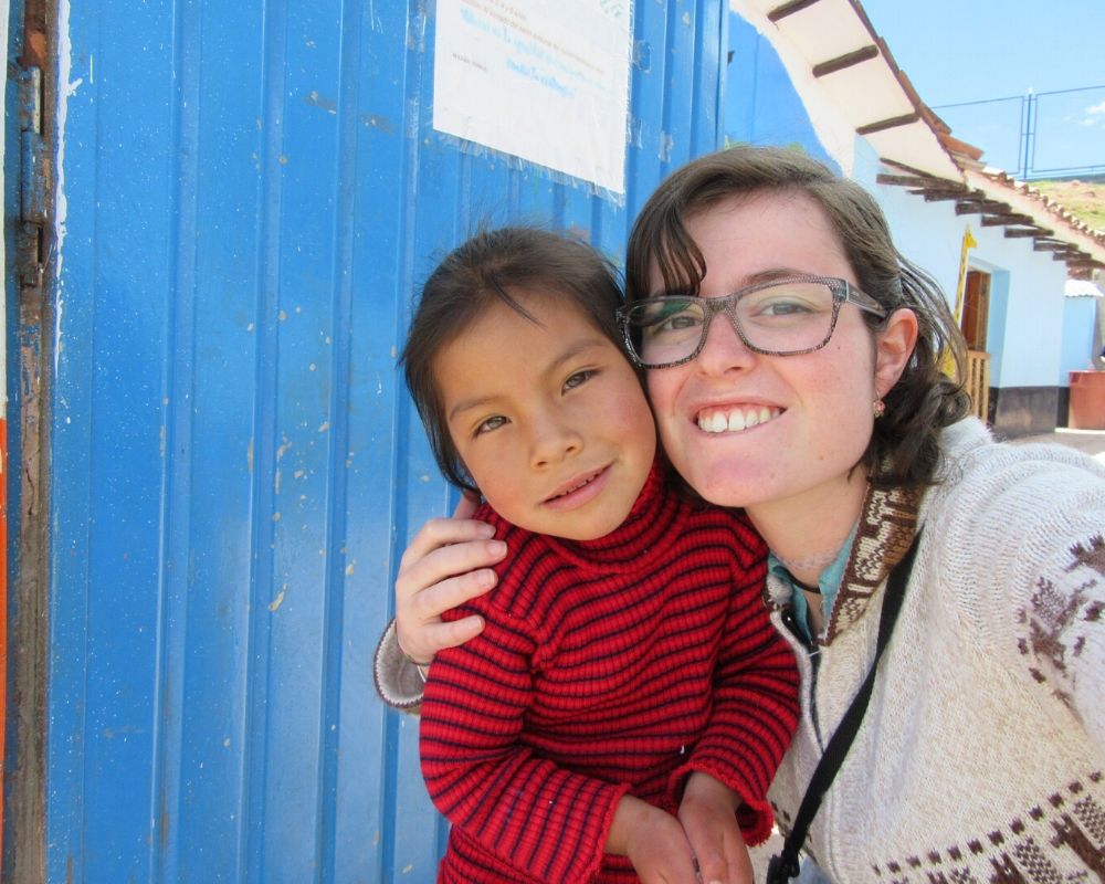 Ragazza abbraccia una bambina peruviana durante un progetto umanitario intrapreso per conoscere se stessa