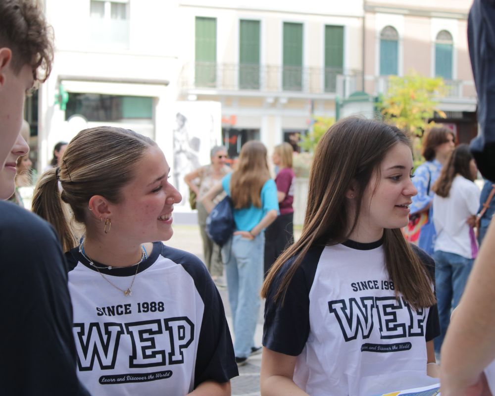 In un contesto urbano due future exchange students sono impegnate in un’attività di socializzazione organizzata in città da WEP