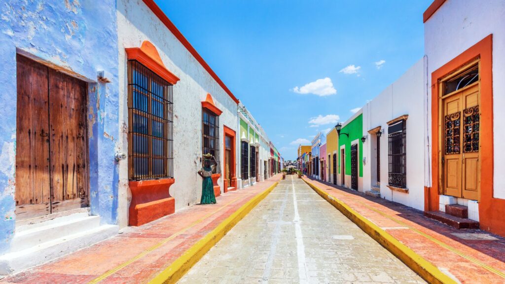 La foto di copertina dell’articolo sulle 15 curiosità del Messico rappresenta una tipica strada messicana con abitazioni basse variopinte