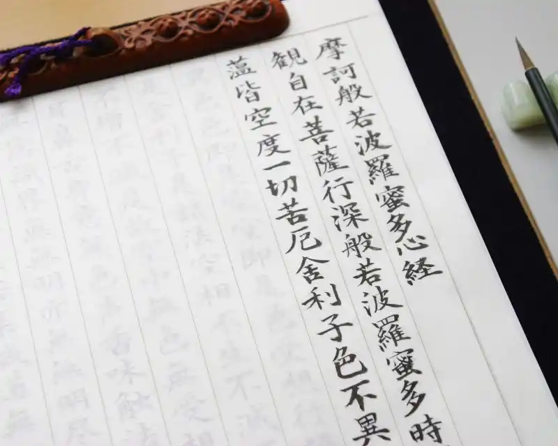 Su un taccuino con un foglio di carta con righe verticali compaiono colonne di caratteri giapponesi