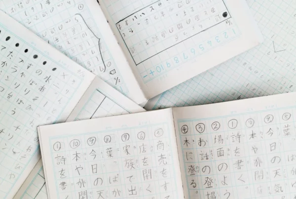 Quaderni aperti con riquadri riempiti con caratteri dei sistemi di scrittura giapponesi. Si tratta di esercizi di scrittura