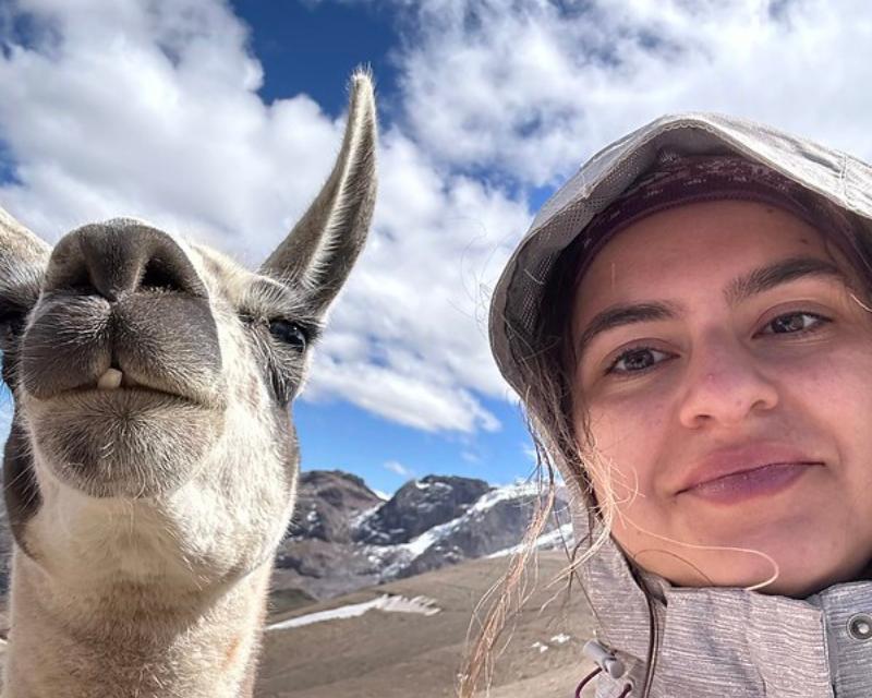 Ragazza in primo piano con un lama in Perù