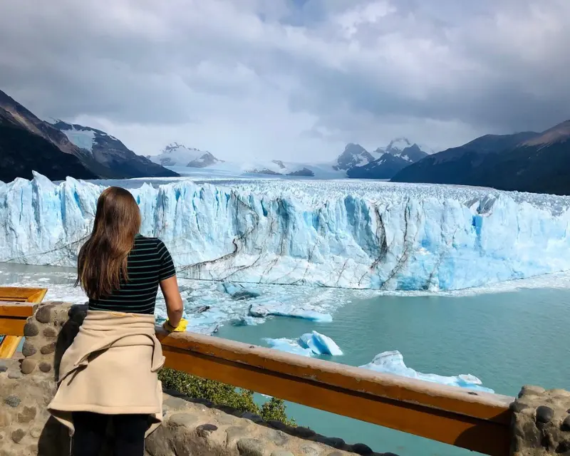 Ragazza di schiena osserva lo spettacolo naturale del perito moreno in Patagnoia nel sud dell'Argentina