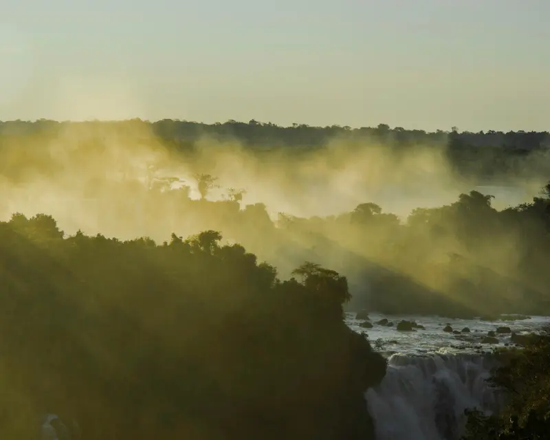 Paesaggio naturale in Argentina con alberi e cascate immersi nella luce del tramonto