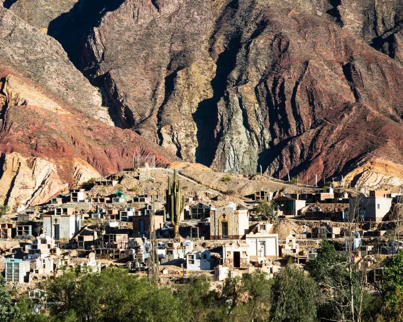 Villaggio dell'entroterra argentino che ricorda un piccolo cimitero tra montagne colorate e cactus.