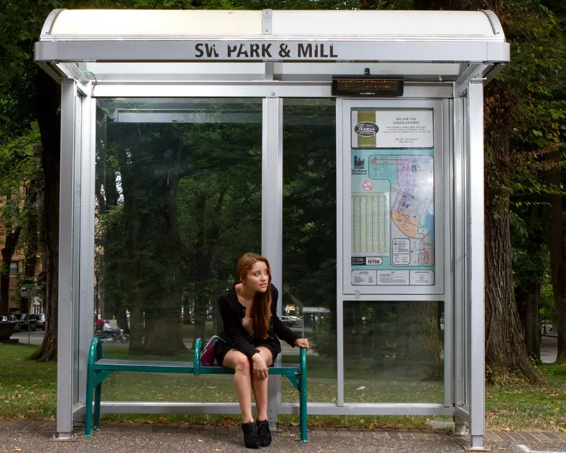 Ragazza timorosa di aver perso l'autobus per essersi distratta con le app per imparare lo spagnolo