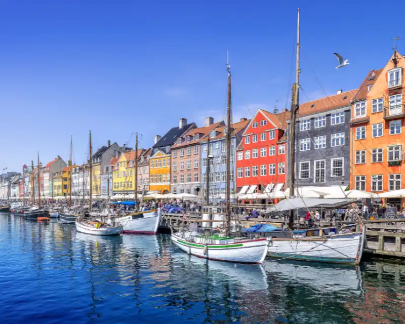Copenaghen, con le sue case colorate sul porto di Nyhavn, incarna lo spirito del Nord durante il Midsommar, tra luce, convivialità e tradizioni nordiche