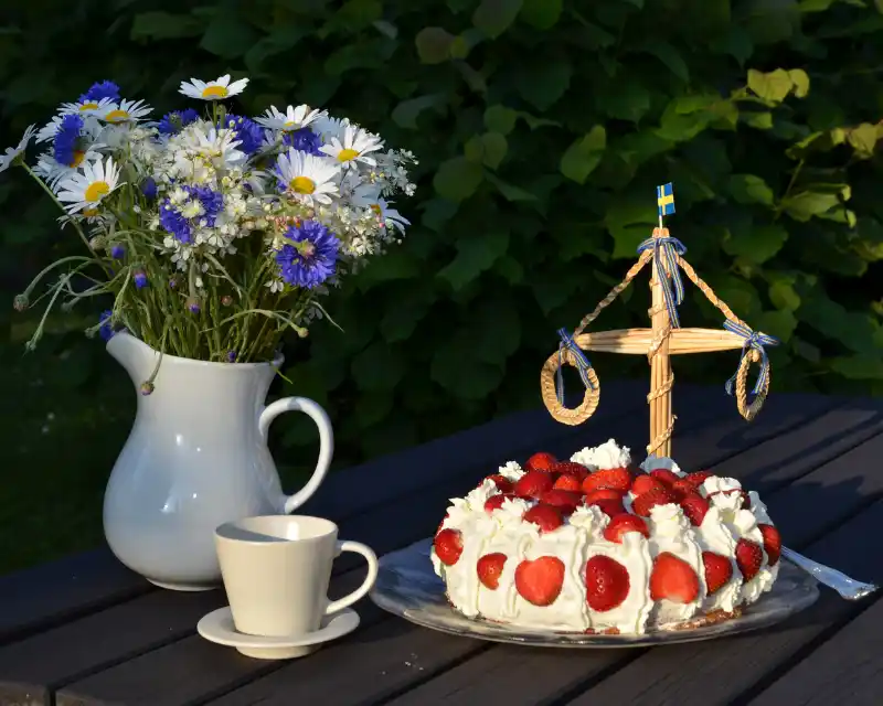 Durante il Midsommar, si festeggia anche a tavola con torte alle fragole, fiori di campo e simboli tradizionali come il midsommarstång
