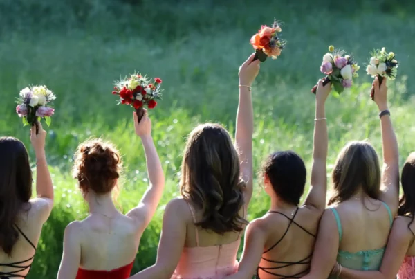 Ragazze sorridenti sollevano i bouquet durante il Prom, il ballo di fine anno americano. Un momento iconico dei balli di fine anno USA.