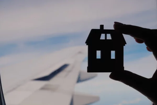 Una casa di carta contro il cielo: simbolo visivo potente della nostalgia di casa all’inizio di un’esperienza all’estero.