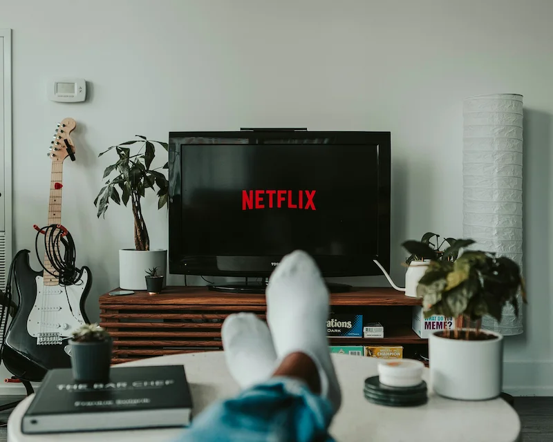 Persona che guarda serie TV francesi su Netflix per imparare il francese comodamente dal divano di casa