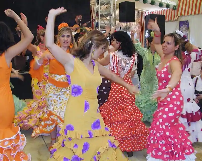 Donne con abiti tradizionali andalusi ballano durante la Feria de Abril di Siviglia, una delle feste tipiche spagnole