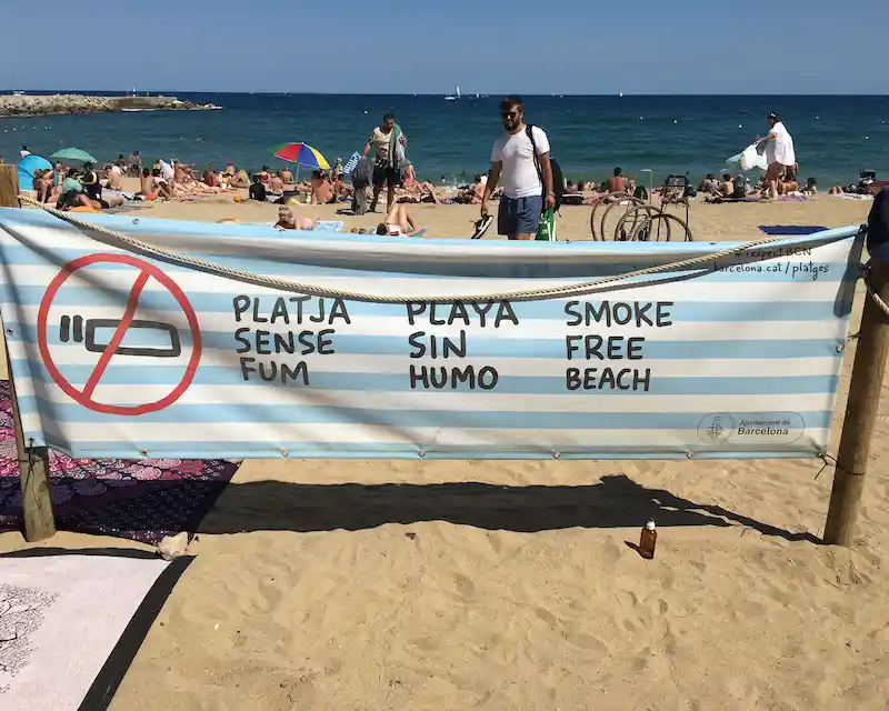 Cartello trilingue catalano-castigliano-inglese su spiaggia di Barcellona, lingue in Spagna