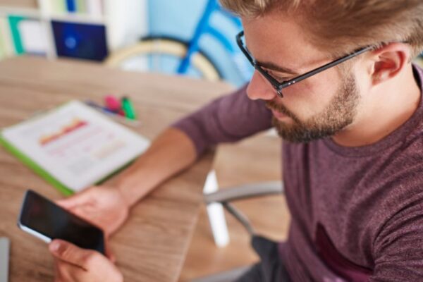 App gratuite per imparare il tedesco Ragazza con gli occhiali e i capelli biondi ha appena scaricato un'app per imparare il tedesco sul cellulare.