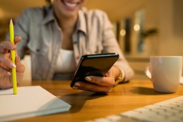 App per imparare il tedesco gratis Ragazza adolescente sorridente sta studiando tedesco con l'uso di un'applicazione.