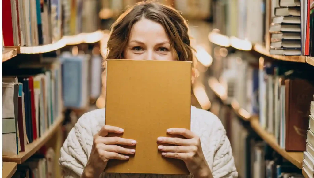 Ragazza arrivata in Germania per un anno all'estero in biblioteca con un libro giallo in mano sulla cultura tedesca