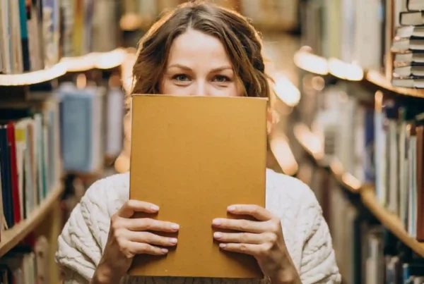 Ragazza arrivata in Germania per un anno all'estero in biblioteca con un libro giallo in mano sulla cultura tedesca