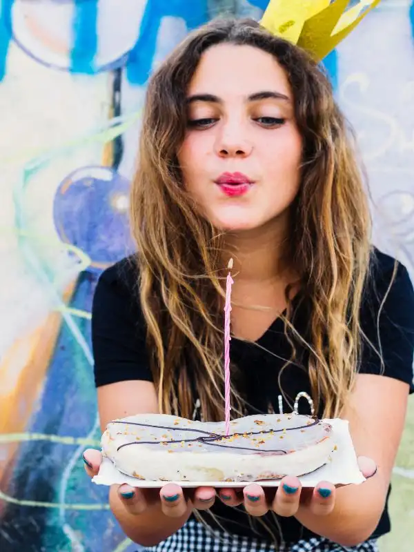 Una ragazza tedesca soffia su una candelina nel giorno del suo compleanno. Curiosità tedesca: gli auguri non si fanno mai in anticipo.