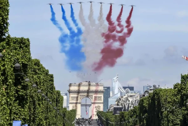 Feste francesi: aerei sorvolano l'Arco di Trionfo con fumo tricolore.