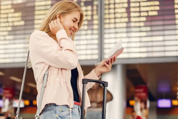 Cosa fare in aeroporto: Donna in aeroporto con bagaglio a mano e documenti di viaggio