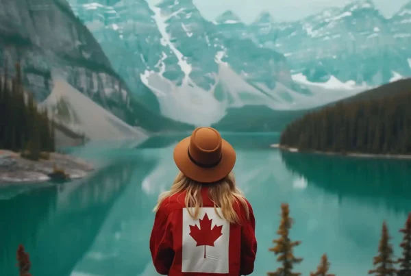 Ragazza con capello e felpa del Canada guarda un lago canadese, una delle curiosità su questo Paese è che ci sono 2 milioni di laghi.