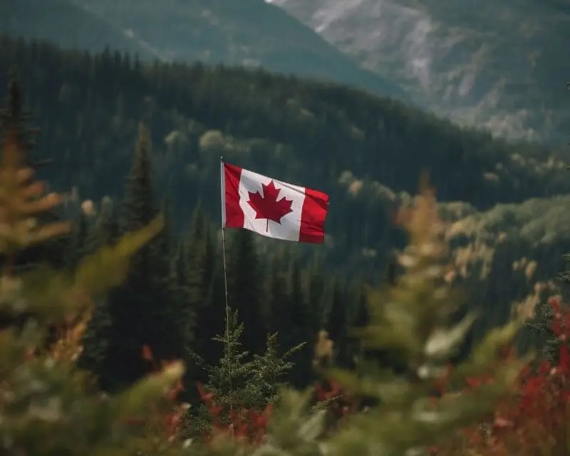 Paesaggio con la bandiera del Canada, ma la curiosità che stupisce di più chi arriva qui per la prima volta è il numero di volte in cui i canadesi chiedono scusa.