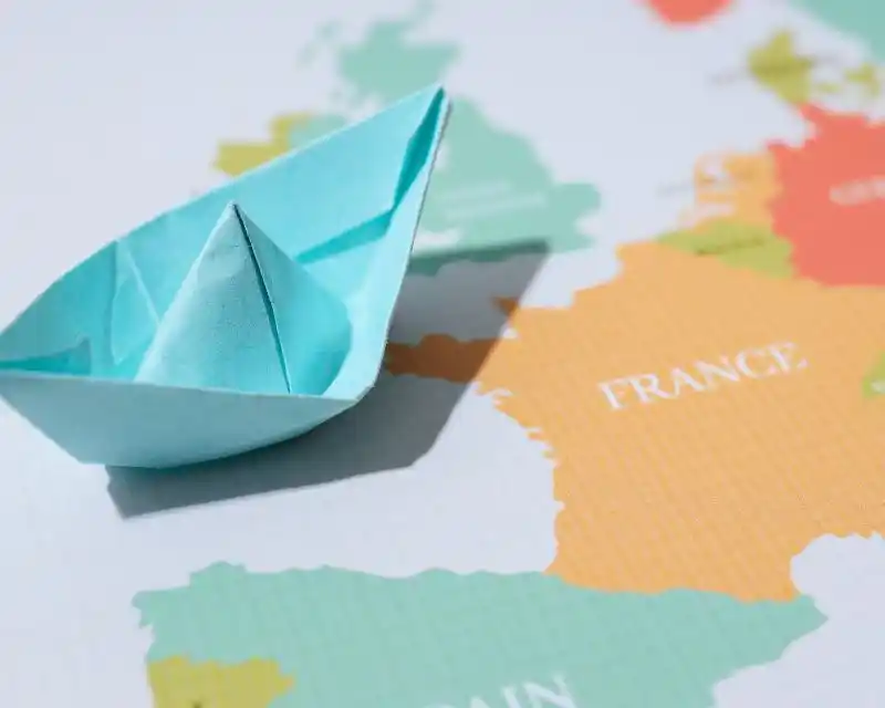 Una cartina in cui si vede una barchetta di carta e l'immagine della Francia. Una curiosità è che questo Paese ha la forma di un esagono.
