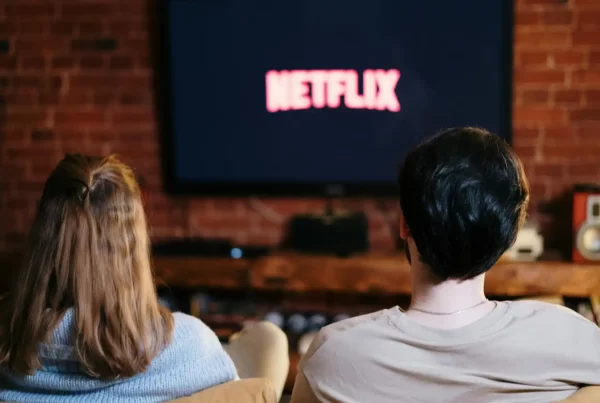 Due persone guardano Netflix sul divano per imparare l'inglese con le serie TV