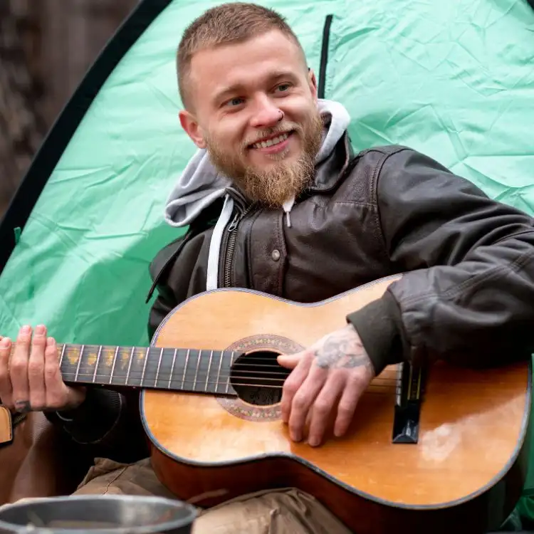 Ragazzo con la chitarra in mano esegue brani di alcune canzoni tipiche della cultura irlandese.