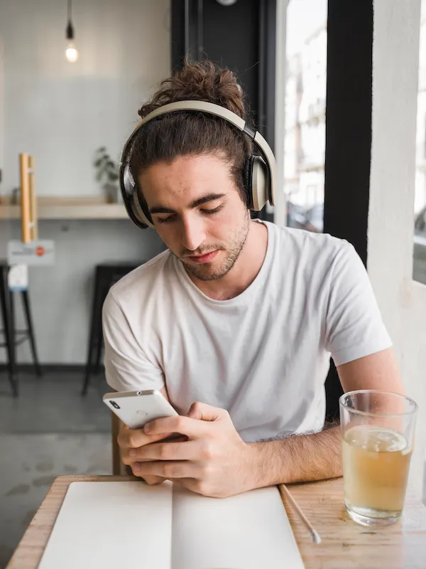 Ragazzo con cuffie che usa uno smartphone per imparare l'inglese con un'app