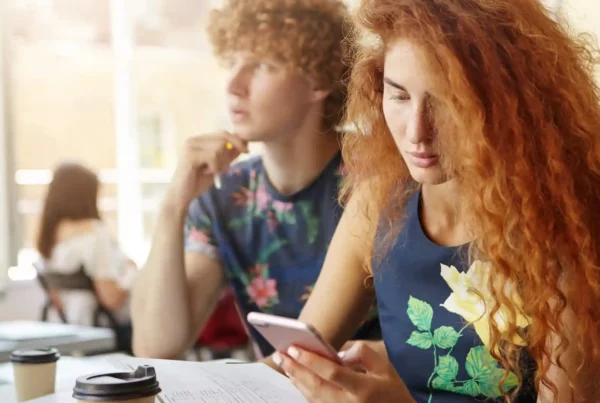 Due studenti in aula che usano lo smartphone per studiare l'inglese con un'app