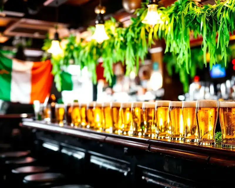 Pub irlandese con tante birre, piantine decorative e una bandiera dell'Irlanda. Una curiosità: il verde è un colore simbolo dell'Irlanda.