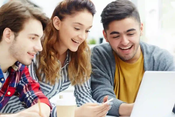 Tre studenti stanno utilizzando internet per trovare corsi online per imparare l'inglese.
