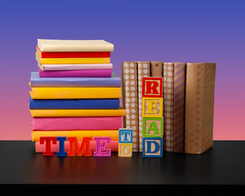 Pila di libri colorati con lettere che formano la scritta "Time to Read", libri per imparare l'inglese da zero