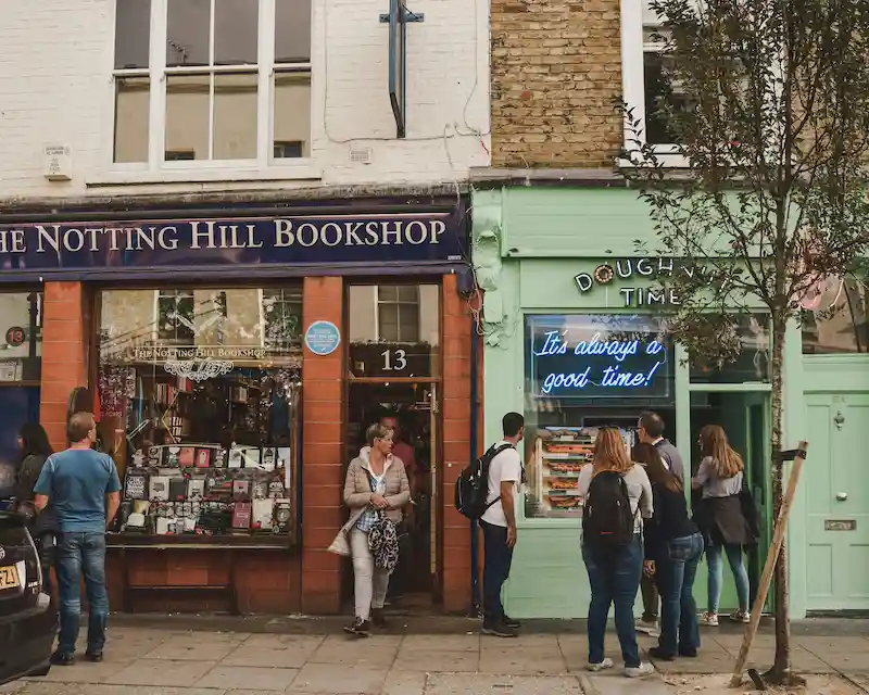 La cultura inglese viva: persone visitano la storica Notting Hill Bookshop a Londra, simbolo della tradizione letteraria britannica e dell'identità culturale inglese