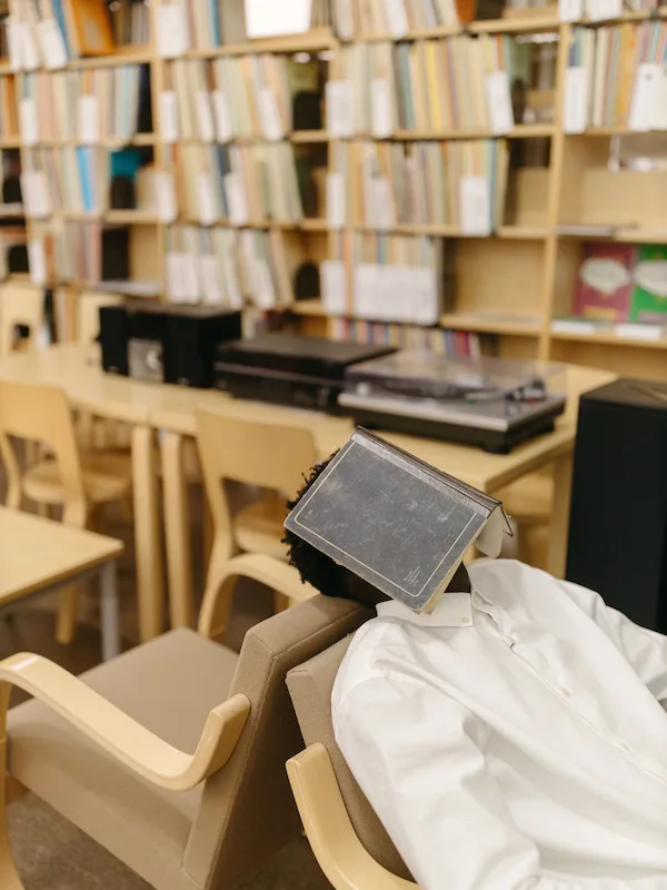 Studente addormentato in biblioteca con un libro sulla testa: imparare l'inglese dormendo è un mito secondo la scienza