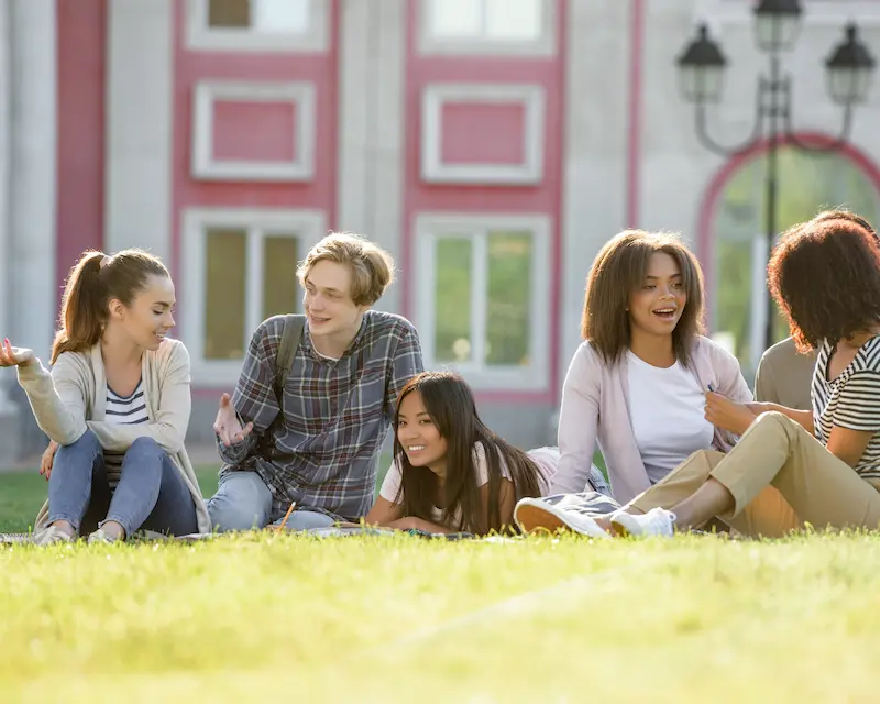 Gruppo di studenti internazionali che conversano in inglese all'aperto durante un viaggio di studio in Inghilterra