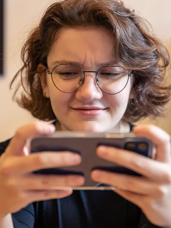 Ragazza concentrata al telefono con un gioco per imparare l'inglese.