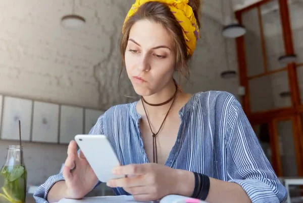 ragazza studia inglese con AI sul telefono in un caffè