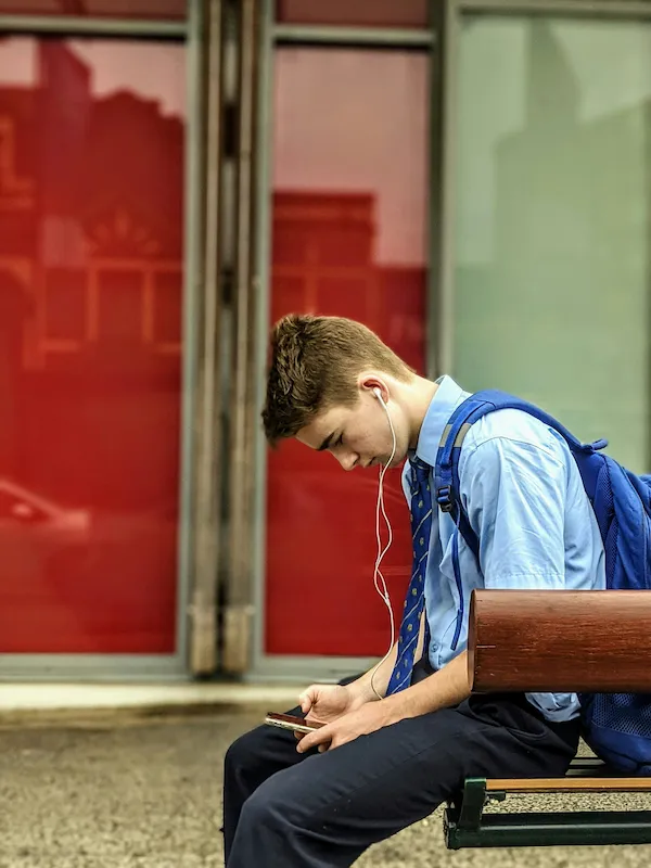 ragazzo seduto impara inglese con IA sul telefono
