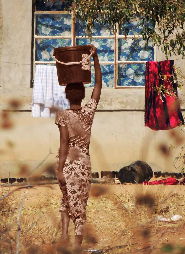 donna con secchio in namibia - kavango